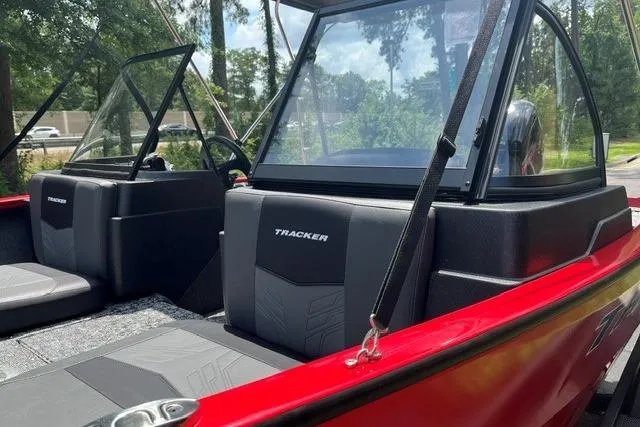 Slide: The Image of 2026 Tracker Pro Guide V-175 Combo boat interior with red exterior and black seating. - 12