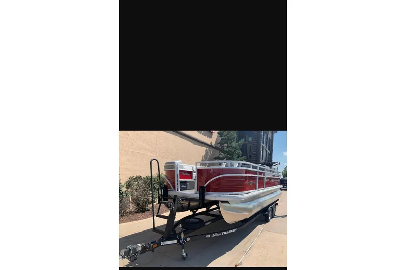 Slide: The Image of 2026 Sun Tracker SportFish 20 DLX pontoon boat on trailer, parked outdoors. - 89