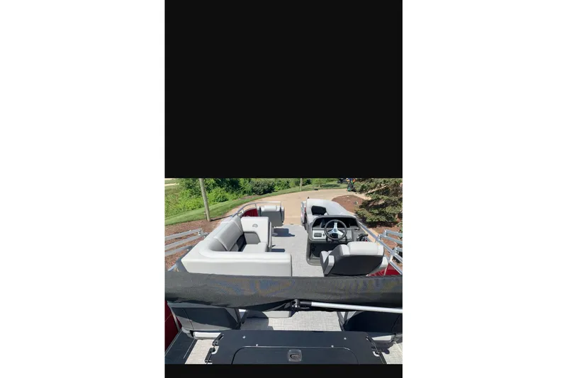 Slide: The Image of 2026 Sun Tracker SportFish 20 DLX pontoon boat interior with seating and steering console. - 90