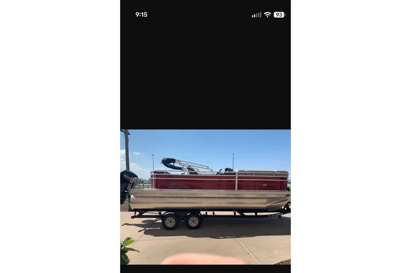 Slide: The Image of 2026 Sun Tracker SportFish 20 DLX pontoon boat on trailer, parked outdoors. - 94