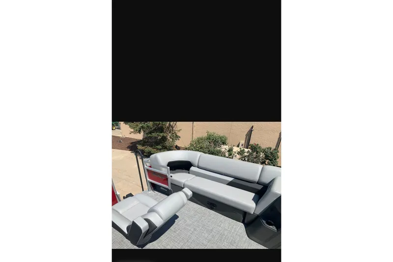 Slide: The Image of 2026 Sun Tracker SportFish 20 DLX boat interior with gray seating and carpeted floor. - 93