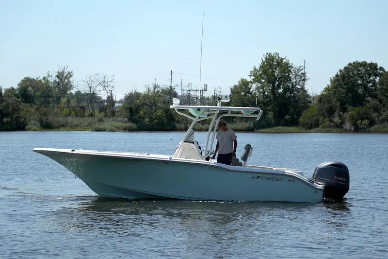 The Image of 2021 Key West 244 Center Console boat on calm water, with trees in the background. - 1