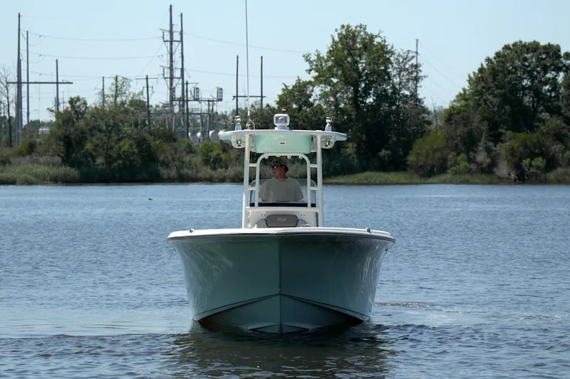 Slide: The Image of 2021 Key West 244 Center Console boat cruising on a calm lake with trees in the background. - 3