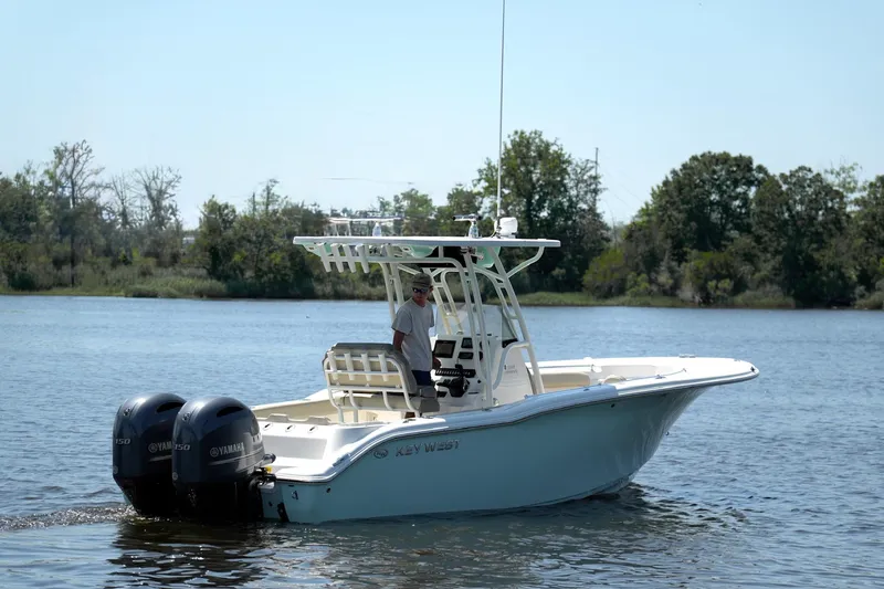 Slide: The Image of 2021 Key West 244 Center Console boat on a calm lake with dual Yamaha engines. - 7