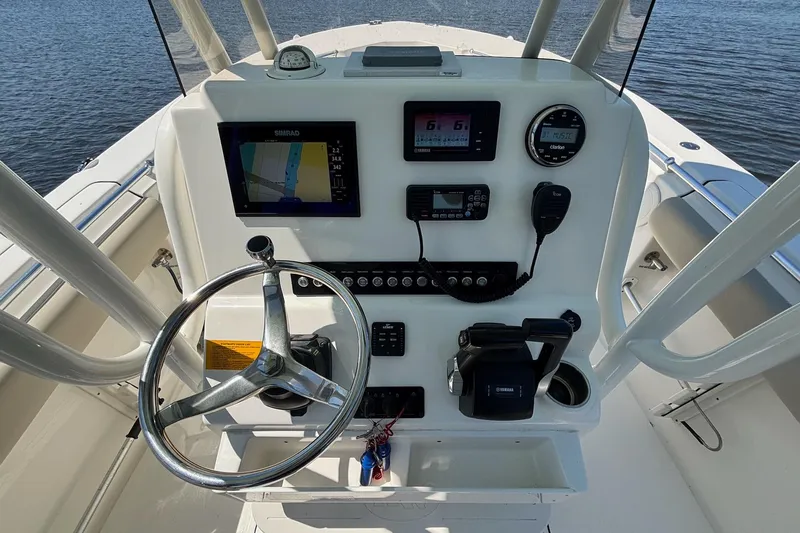 Slide: The Image of 2021 Key West 244 Center Console boat dashboard with steering wheel and navigation instruments. - 8