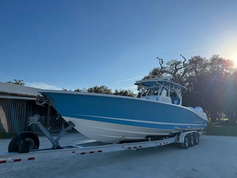 Slide: The Image of 2018 Concept 392 Family Edition boat on trailer, blue hull, parked outdoors. - 10