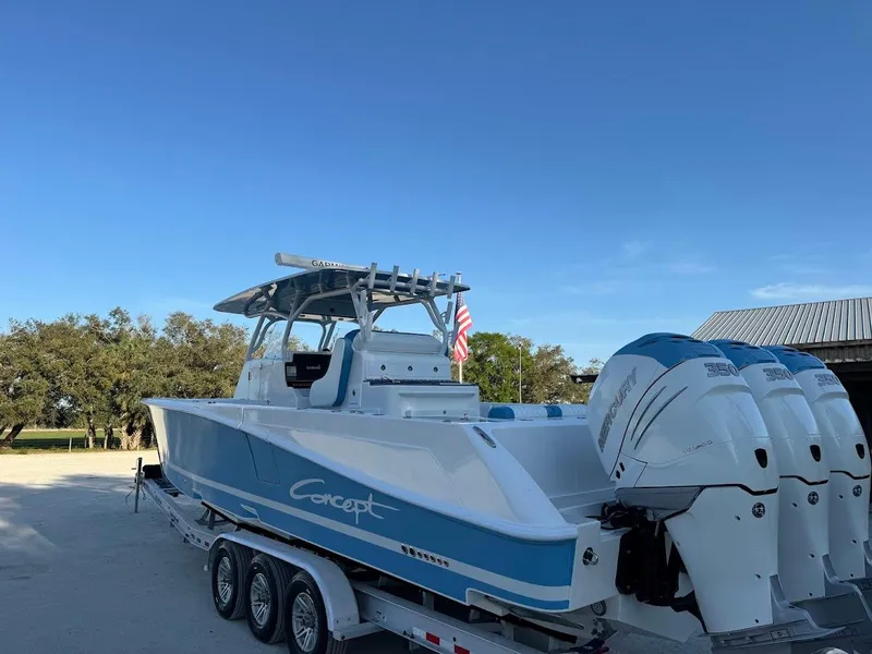 Slide: The Image of 2018 Concept 392 Family Edition boat on trailer with triple engines, clear sky background. - 12