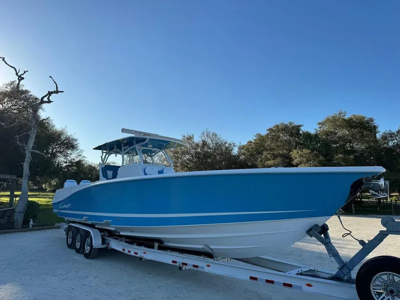 Slide: The Image of 2018 Concept 392 Family Edition boat on trailer, blue hull, parked outdoors. - 3