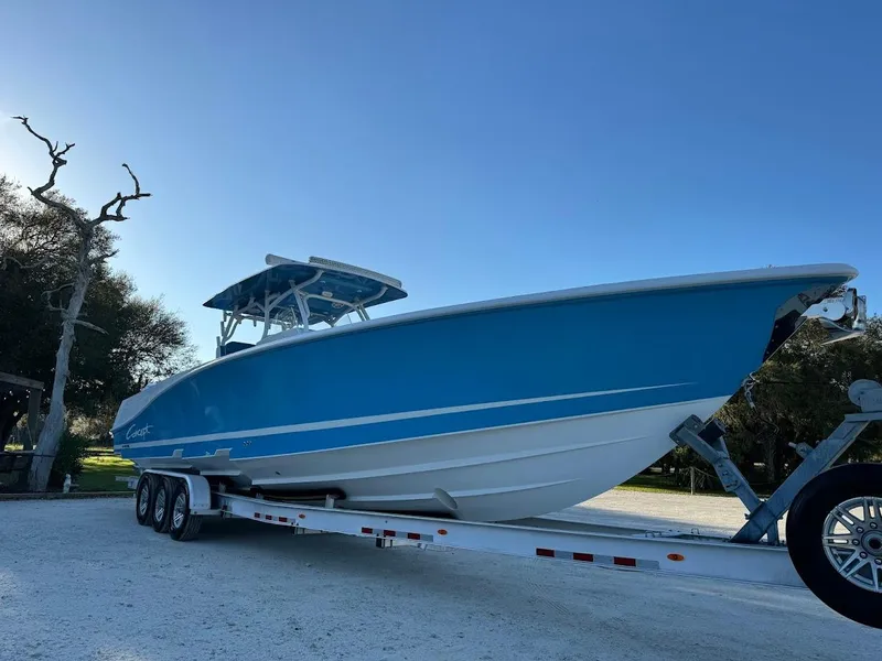 Slide: The Image of Blue 2018 Concept 392 Family Edition boat on trailer, parked outdoors. - 5