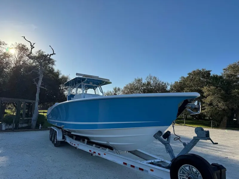 Slide: The Image of Blue 2018 Concept 392 Family Edition boat on trailer, parked outdoors under clear sky. - 7