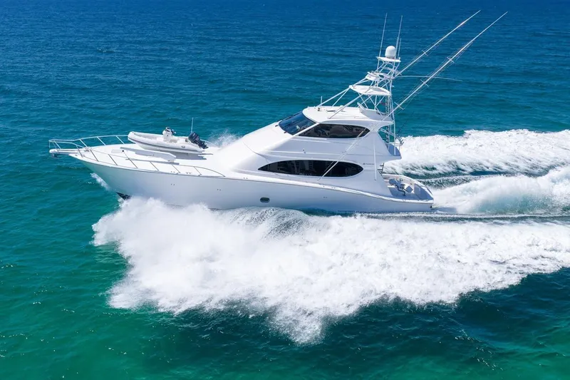 Slide: The Image of 2008 Hatteras 77 Convertible yacht cruising on clear blue ocean waters. - 15