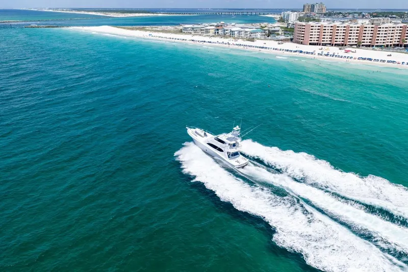 Slide: The Image of Aerial view of 2008 Hatteras 77 Convertible yacht cruising near a scenic coastline. - 17