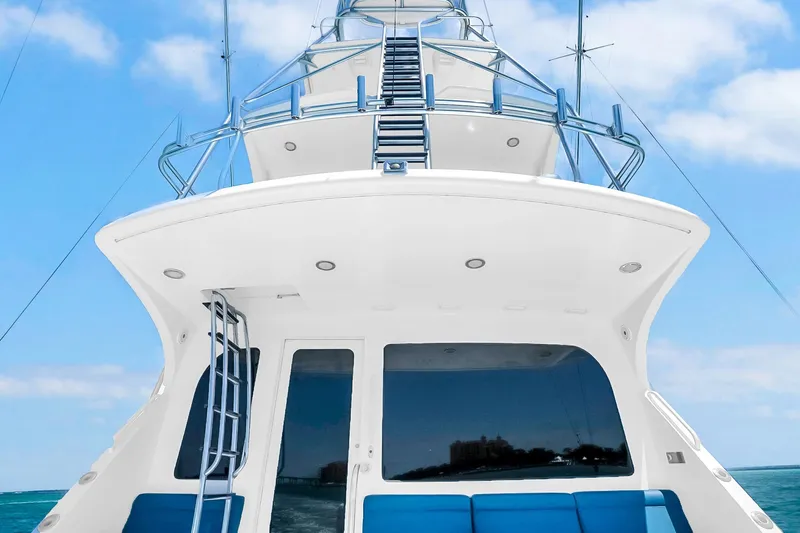 Slide: The Image of 2008 Hatteras 77 Convertible yacht with sleek design and blue sky backdrop. - 23