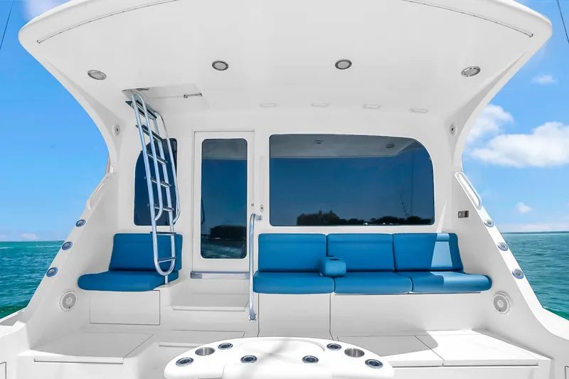 Slide: The Image of Luxurious 2008 Hatteras 77 Convertible yacht with blue seating and ocean view. - 24