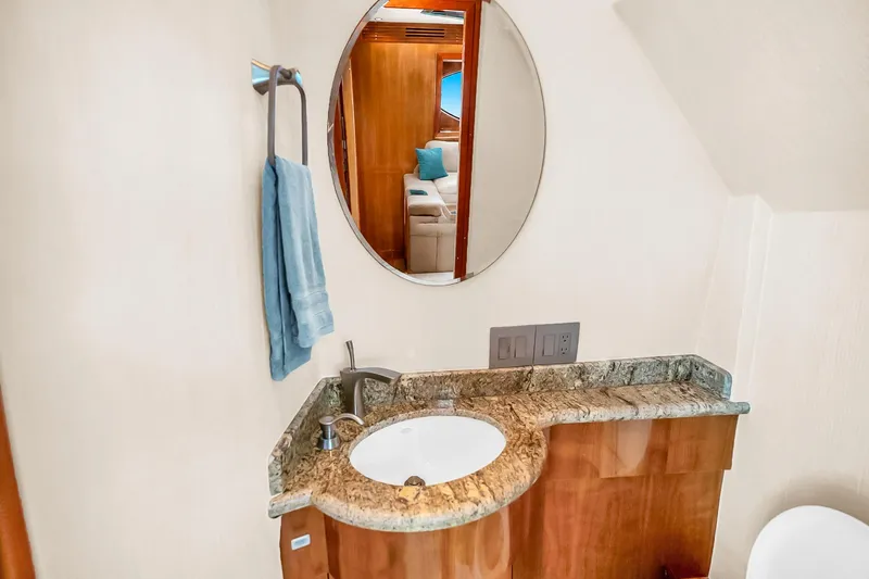 Slide: The Image of Luxurious bathroom in 2008 Hatteras 77 Convertible yacht with granite countertop and round mirror. - 29