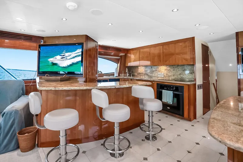 Slide: The Image of Luxurious interior of 2008 Hatteras 77 Convertible yacht with modern kitchen and seating area. - 34