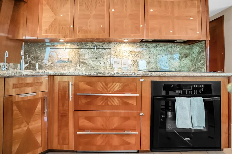 Slide: The Image of Luxurious kitchen interior of 2008 Hatteras 77 Convertible yacht with wood cabinetry and modern appliances. - 39
