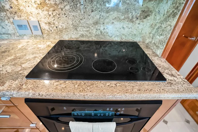 Slide: The Image of Luxury yacht kitchen with sleek black cooktop on granite countertop, Hatteras 77 Convertible 2008. - 40