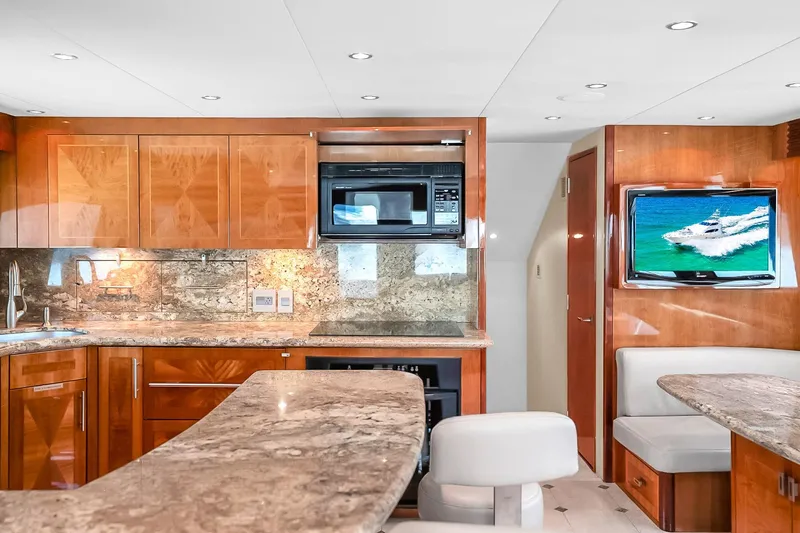 Slide: The Image of Luxurious interior of 2008 Hatteras 77 Convertible yacht with modern kitchen and seating area. - 43