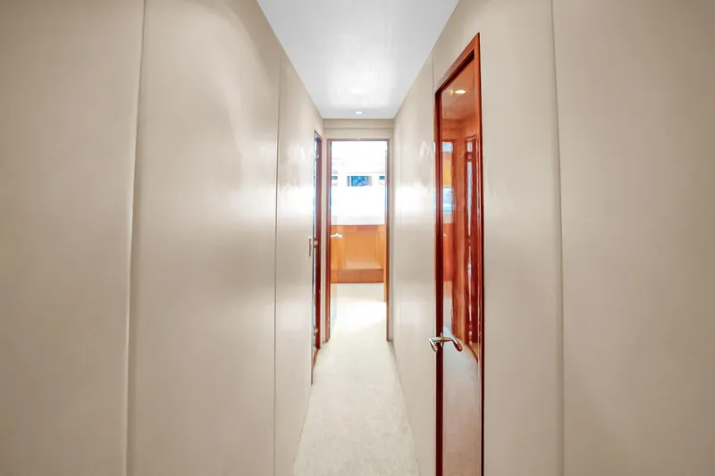 Slide: The Image of Hallway inside 2008 Hatteras 77 Convertible yacht, featuring sleek wooden doors and modern design. - 49