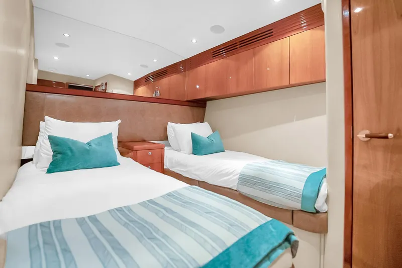 Slide: The Image of Interior of 2008 Hatteras 77 Convertible yacht with twin beds and wooden cabinetry. - 61