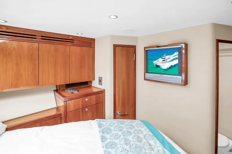 Slide: The Image of Interior of 2008 Hatteras 77 Convertible yacht bedroom with TV and wooden cabinetry. - 69