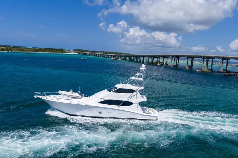 Slide: The Image of 2008 Hatteras 77 Convertible yacht cruising in clear blue waters under a sunny sky. - 7