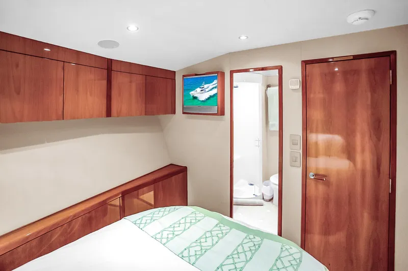 Slide: The Image of Luxurious cabin interior of 2008 Hatteras 77 Convertible yacht with wood finishes and ensuite bathroom. - 77