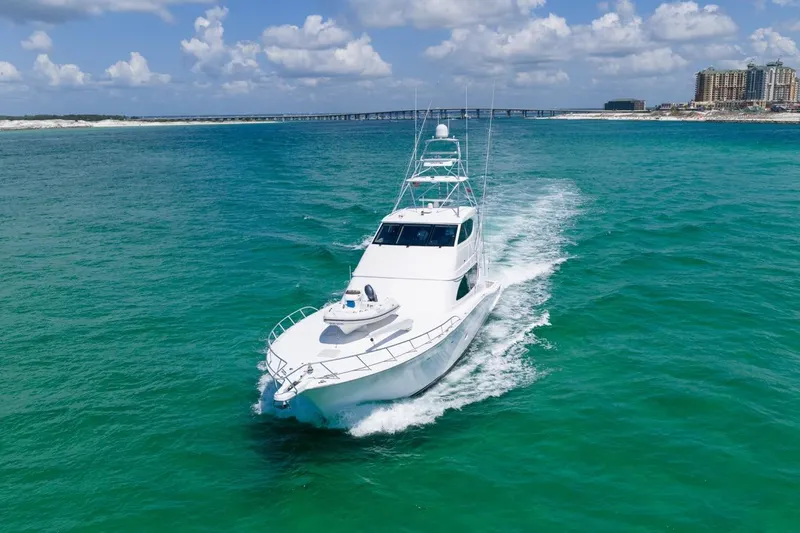 Slide: The Image of 2008 Hatteras 77 Convertible yacht cruising in turquoise waters under a blue sky. - 9