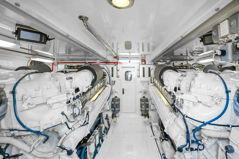 Slide: The Image of Engine room of 2008 Hatteras 77 Convertible yacht, featuring dual engines and pristine white interior. - 94