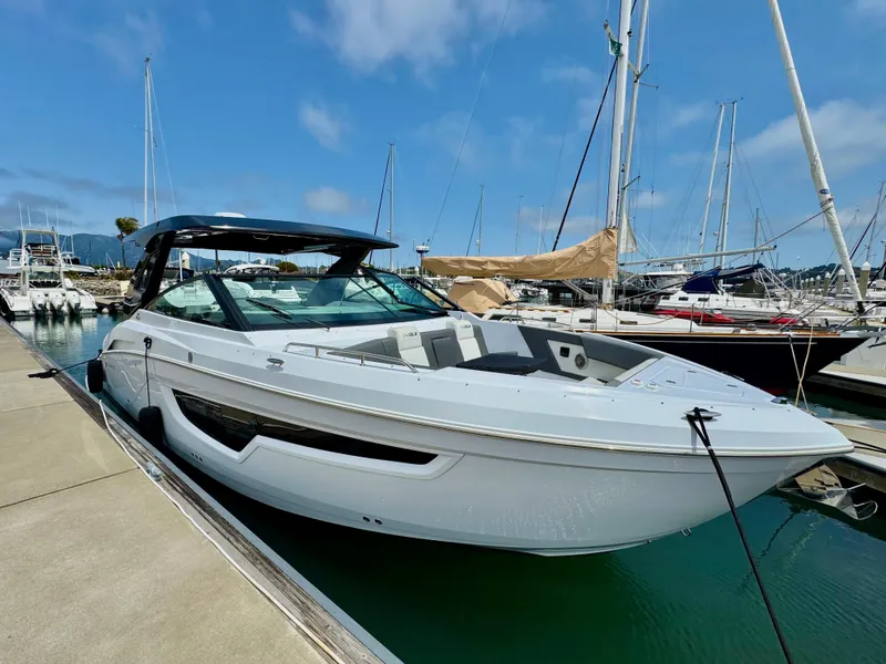 Slide: The Image of 2023 Cruisers Yachts 34 GLS I/O docked at marina, clear sky background. - 10