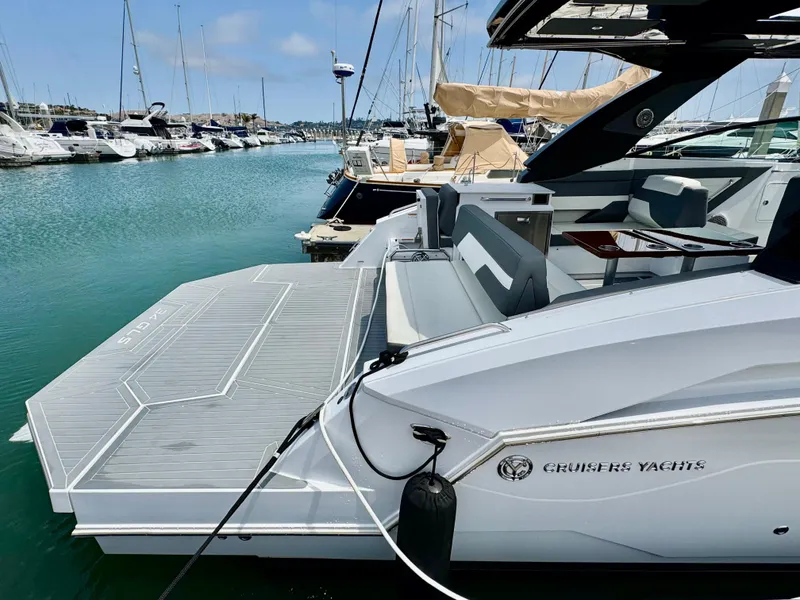 Slide: The Image of 2023 Cruisers Yachts 34 GLS I/O docked in a marina, showcasing sleek design and spacious deck. - 12