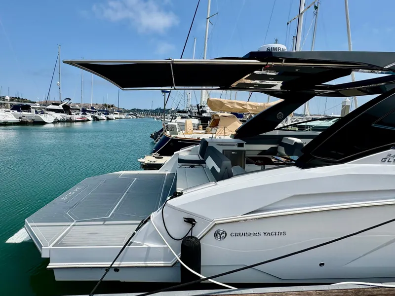 Slide: The Image of 2023 Cruisers Yachts 34 GLS I/O docked at marina, featuring sleek design and spacious deck. - 13