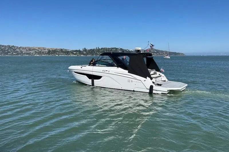 Slide: The Image of 2023 Cruisers Yachts 34 GLS I/O on calm waters under clear blue sky. - 3