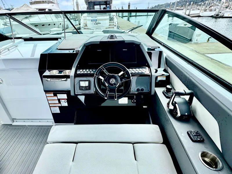 Slide: The Image of 2023 Cruisers Yachts 34 GLS I/O helm with modern controls and waterfront view. - 30