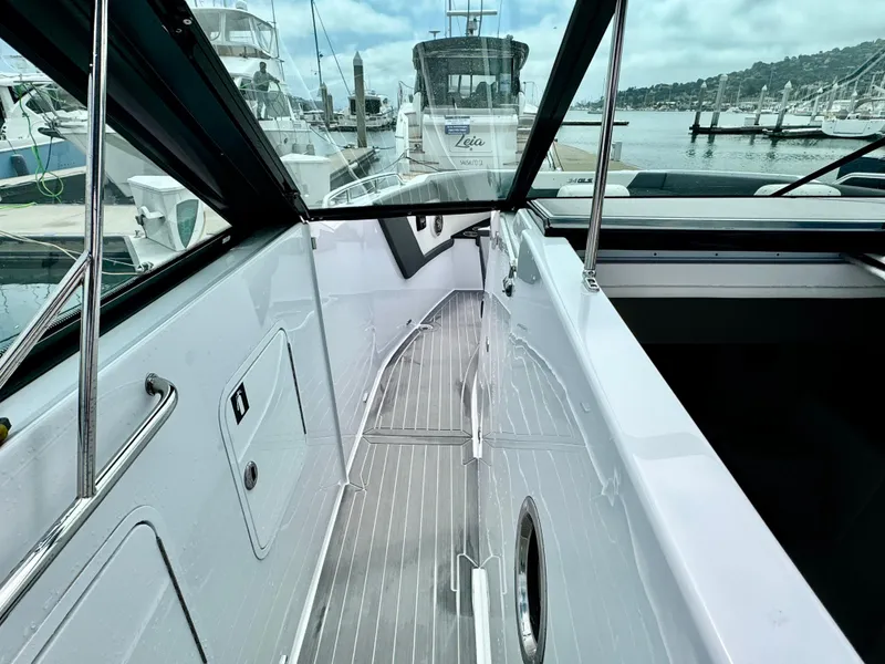 Slide: The Image of 2023 Cruisers Yachts 34 GLS I/O boat docked at marina, showcasing sleek deck design. - 34