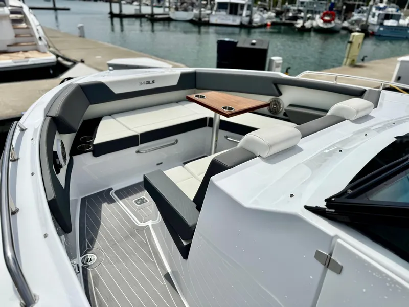 Slide: The Image of 2023 Cruisers Yachts 34 GLS I/O boat interior with seating and table at marina. - 35