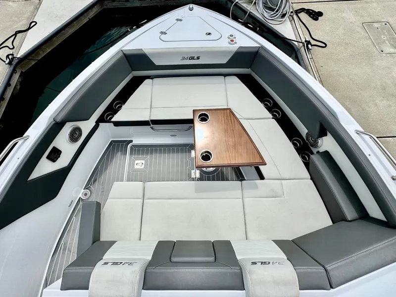 Slide: The Image of 2023 Cruisers Yachts 34 GLS I/O interior with seating and table, docked at marina. - 36
