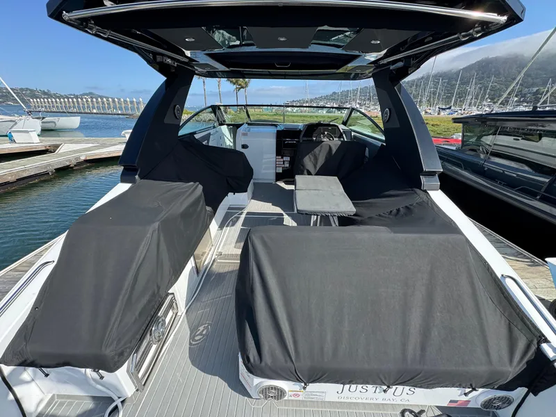 Slide: The Image of 2023 Cruisers Yachts 34 GLS I/O boat interior with covered seating at a marina. - 68