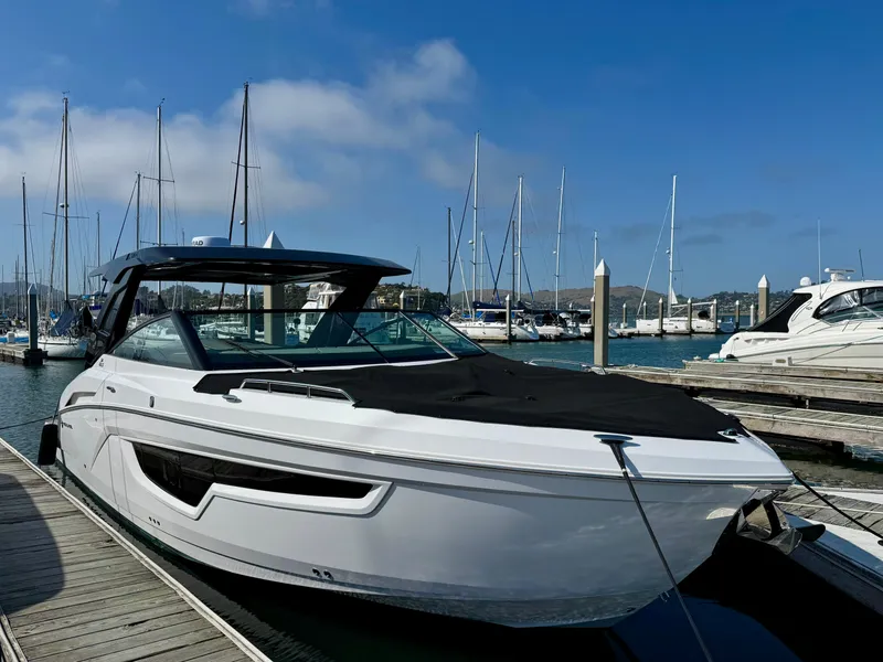 Slide: The Image of 2023 Cruisers Yachts 34 GLS I/O docked at marina with sailboats in background. - 69
