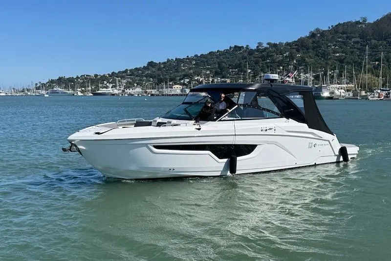 Slide: The Image of 2023 Cruisers Yachts 34 GLS I/O in scenic harbor, sleek design, calm waters. - 74