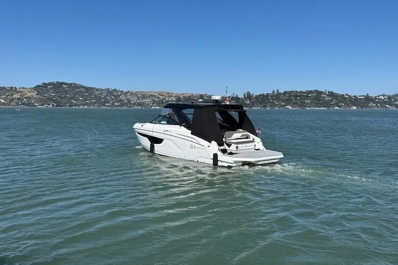 Slide: The Image of 2023 Cruisers Yachts 34 GLS I/O navigating serene waters under clear blue skies. - 75