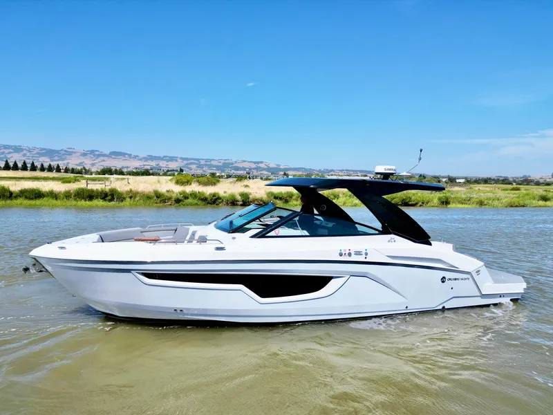 Slide: The Image of 2023 Cruisers Yachts 34 GLS I/O on a serene waterway under clear blue skies. - 9