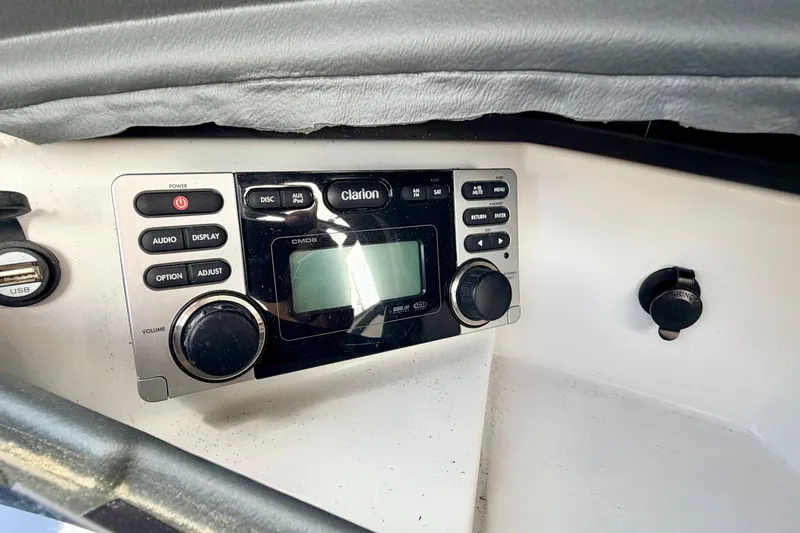 Slide: The Image of Clarion audio system in 2014 Tigé R20 boat dashboard, featuring control knobs and display. - 43