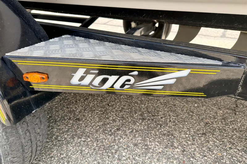 Slide: The Image of 2014 Tigé R20 trailer step with logo and yellow accents on textured metal surface. - 80