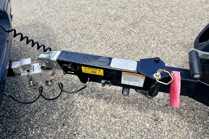 Slide: The Image of Trailer hitch of a 2014 Tigé R20 boat on asphalt surface. - 76