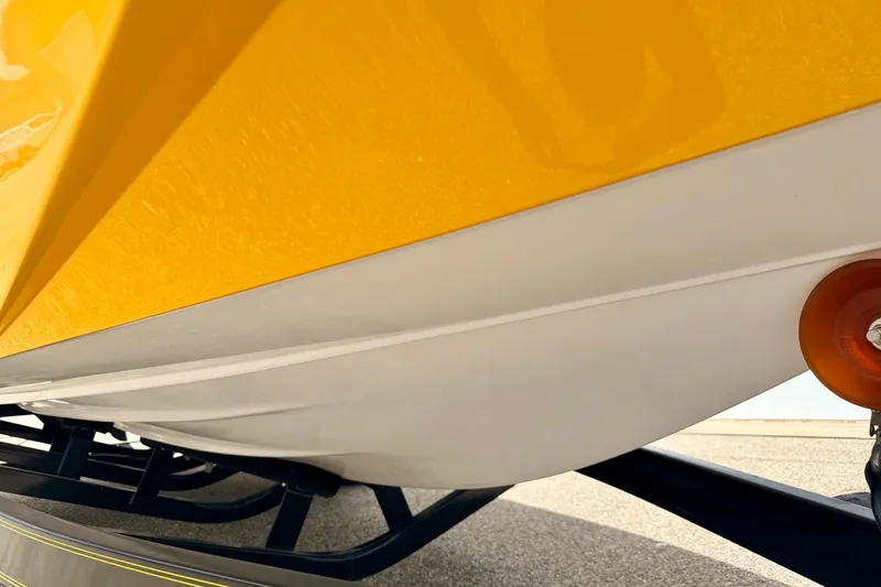 Slide: The Image of Close-up of a 2014 Tigé R20 boat hull in yellow and white on a trailer. - 18