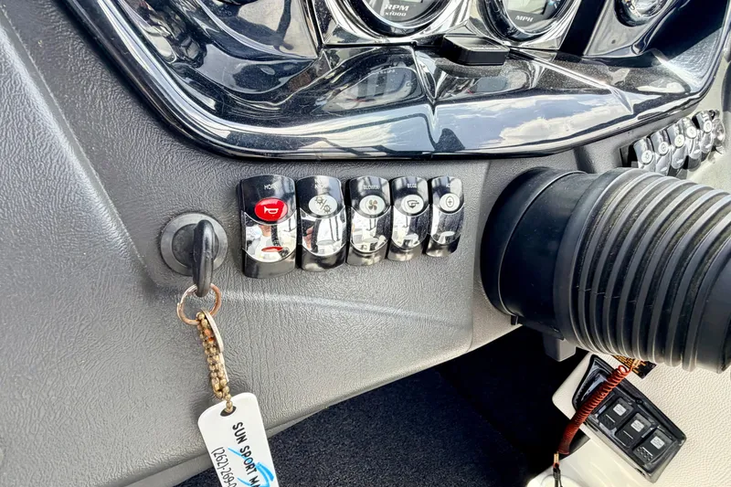Slide: The Image of Dashboard controls of a 2014 Tigé R20 boat with key and switches. - 48