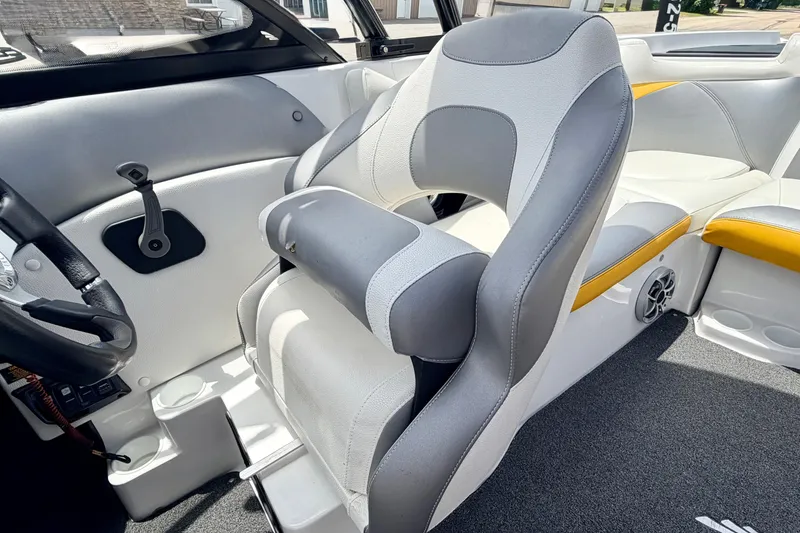 Slide: The Image of 2014 Tigé R20 boat interior with gray and white seating, steering wheel, and speaker. - 53