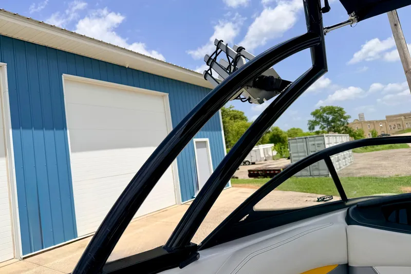 Slide: The Image of 2014 Tigé R20 boat near blue warehouse under clear sky. - 69